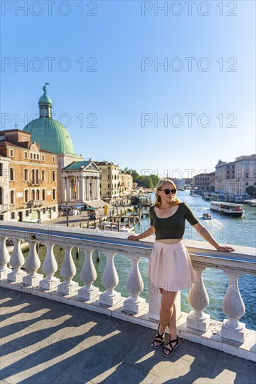 Young woman leaning against bridge railing on the Grand Canal