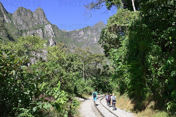 Hikers on the railway tracks in the Urubamba Valley towards Cusco