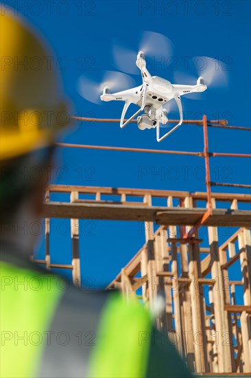 Female pilot flies drone quadcopter inspecting construction site