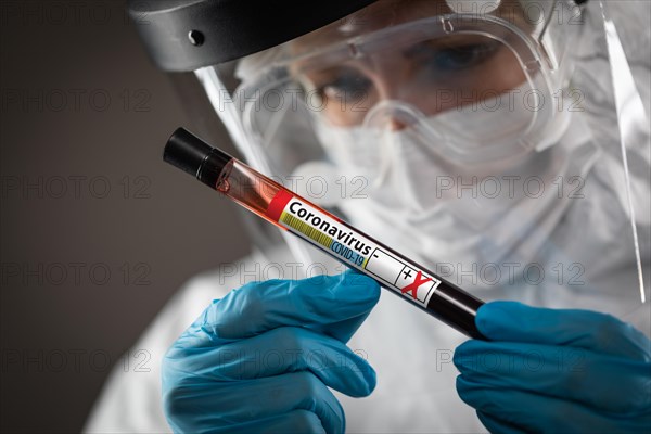 Female Lab Worker Holds Test Tube of Blood Labeled Coronavirus COVID-19 Disease