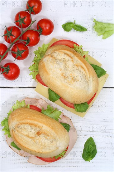 Roll sandwich baguette topped with cheese and ham from above on wooden board