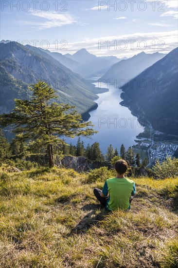 Hiker sitting and looking at Plansee