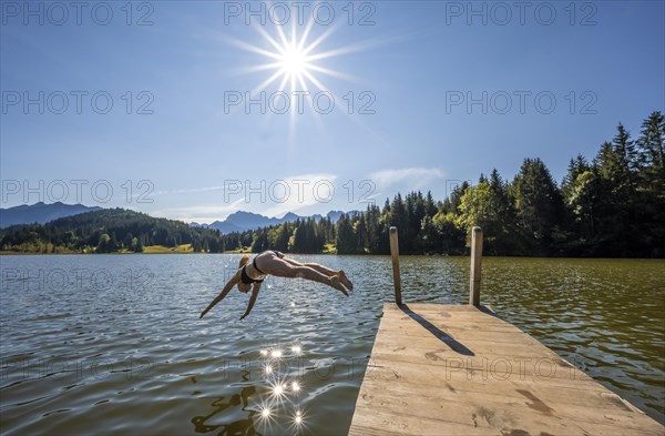 Young woman taking a header into a lake