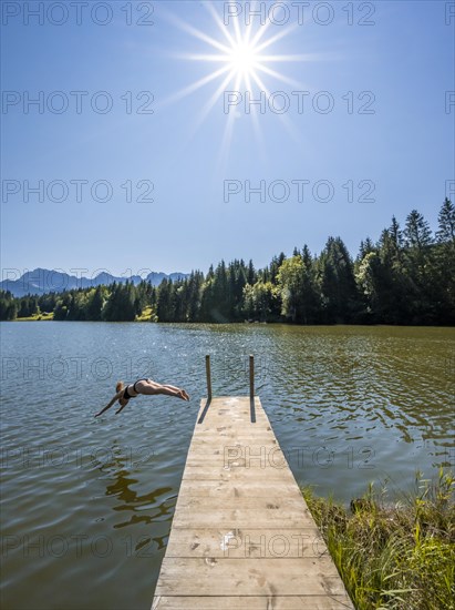Young woman taking a header into a lake