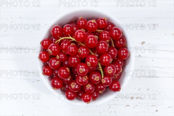 Red currants berries from above wooden board
