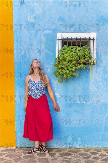 Young woman in front of blue house