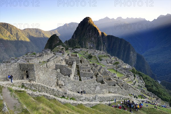 Inca ruined city with Mount Huayna Picchu with first rays of sun
