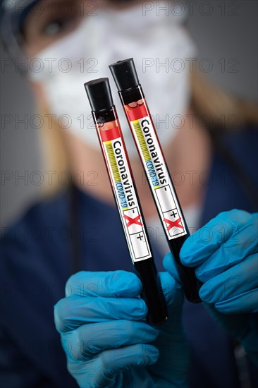 Female Lab Worker Holds Test Tubes of Blood Labeled Coronavirus COVID-19 Disease