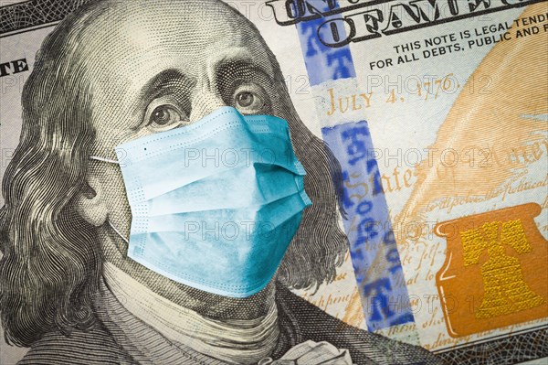 Benjamin franklin with worried and concerned expression wearing medical face mask on one hundred dollar bill