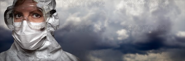 Doctor or nurse wearing personal protective equipment over stormy clouds banner