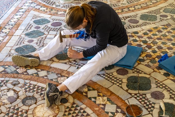 Restorer working on floor mosaic