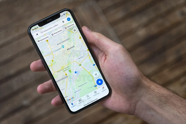 Hand haelt iPhone 11 Pro mit Google Maps App