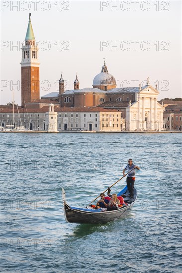 Gondolier rowing in Venetian gondola on the sea