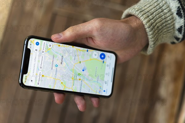 Hand haelt iPhone 11 Pro mit Google Maps App