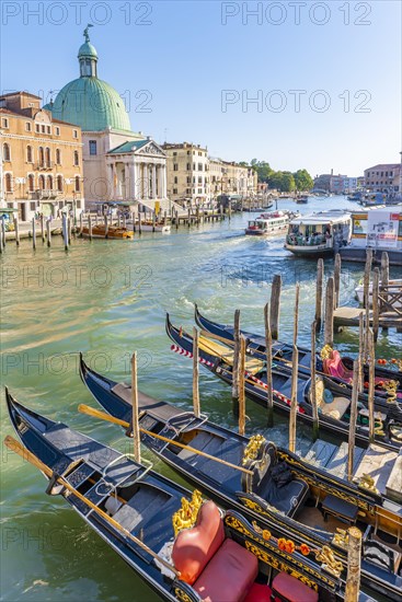 Gondolas and boats on the Grand Canal with church San Simeone Piccolo at the Ponte degli Scalzi