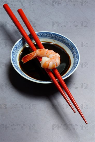 Cooked shrimp on chopsticks and shell with soy sauce