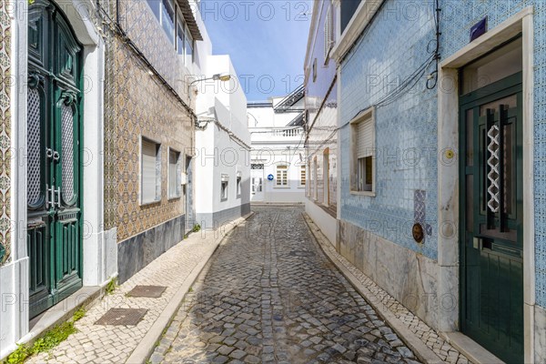 Narrow street with traditional fishermen's houses in Olhao