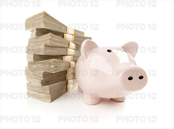 Pink piggy bank with stacks of hundreds of dollars isolated on a white background