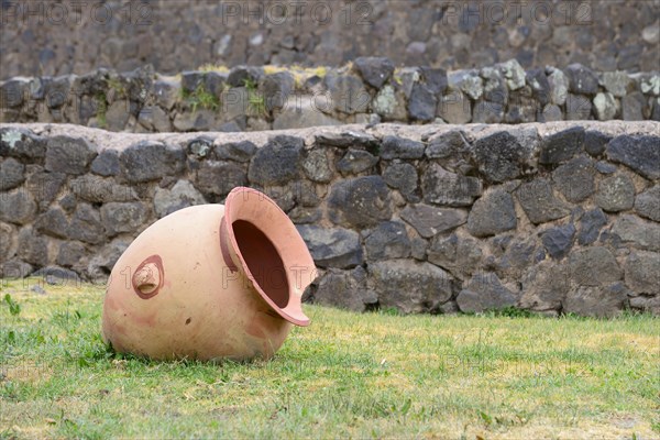 Stone wall and broken clay jar in Raqchi