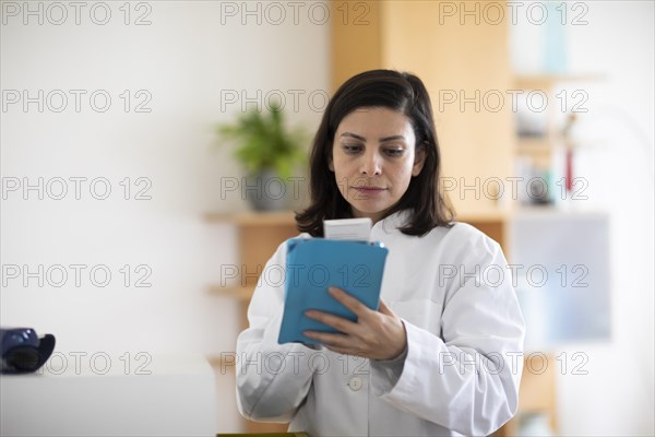 Pharmacist with medicine in a pharmacy working with modern technology and smock