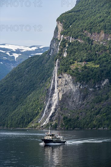 Ferry boat before a waterfall in Geirangerfjord