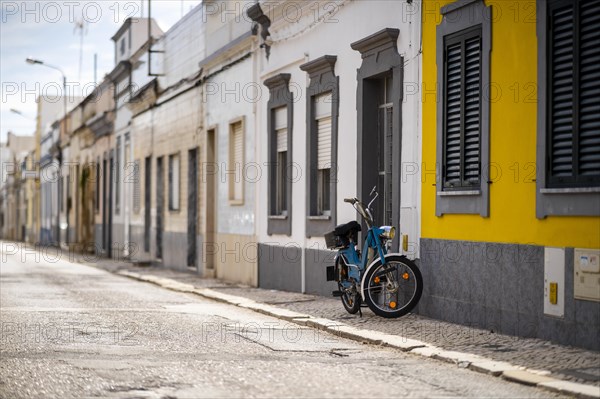 Vintage motorbike parked by typical fisherman's house in Olhao