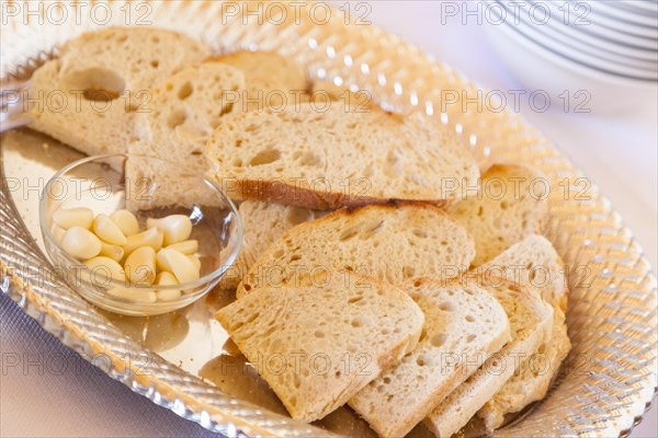 Tray of fresh made sourdough bread with garlic cloves on a serving table