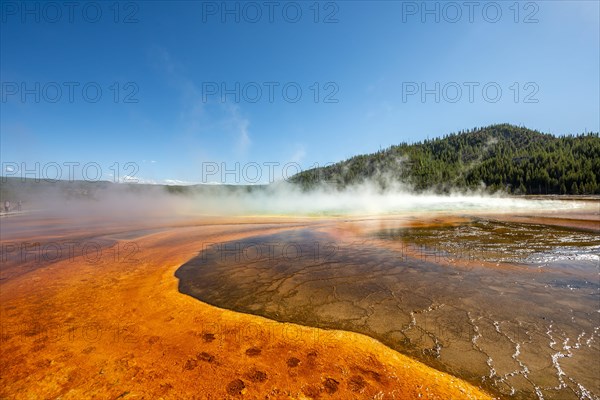 Steaming hot spring with colored mineral deposits