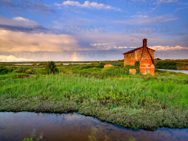 Abandoned stone house in the evening light in the lagoon of Venice