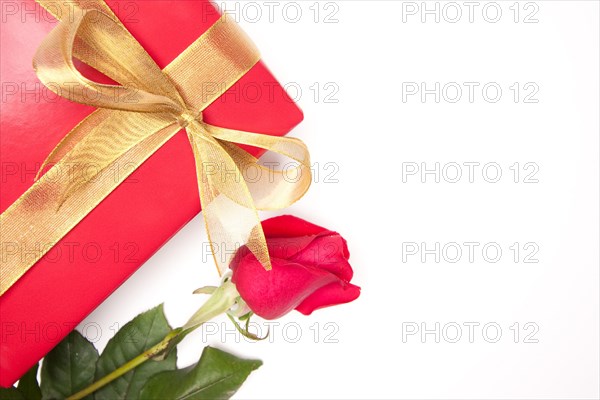 Gift with gold ribbon and rose isolated on a white background
