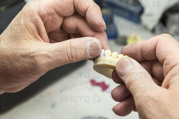 Male dental technician working on A 3D printed mold for tooth implants in the lab