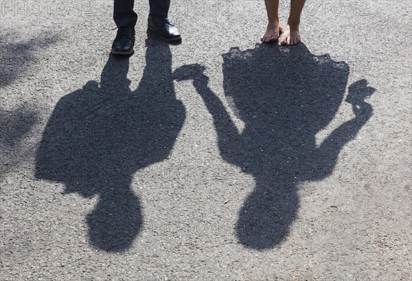 Shadow image of bride and groom on asphalt path