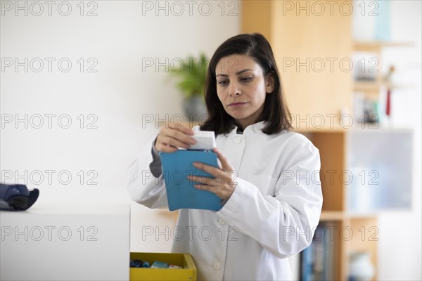 Pharmacist with medicine in a pharmacy working with modern technology and smock