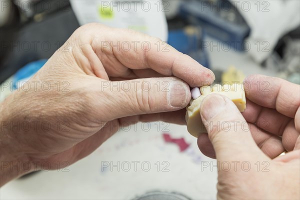 Male dental technician working on A 3D printed mold for tooth implants in the lab