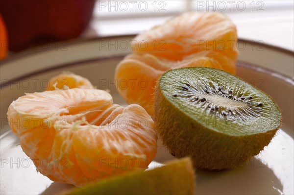 Kiwi and clementine tangerines on a plate in early morning light