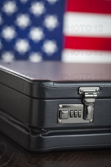 Black leather briefcase resting on table with american flag behind