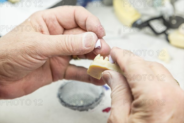 Male dental technician working on A 3D printed mold for tooth implants in the lab