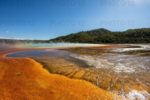 Steaming hot spring with colored mineral deposits