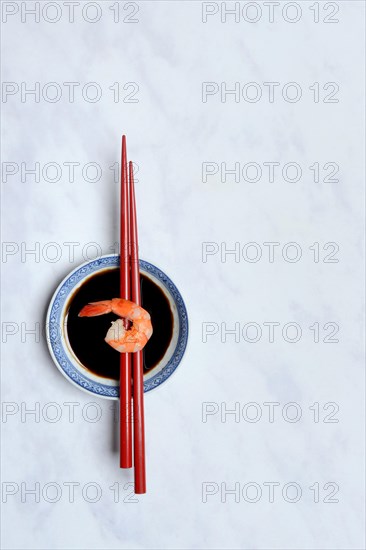 Cooked shrimp on chopsticks and shell with soy sauce