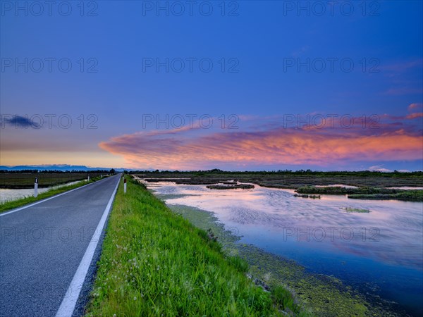 Lonely road and dramatic clouds over the lagoon of Venice