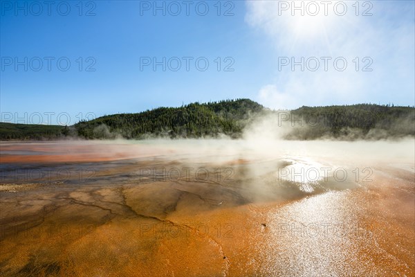 Steaming hot spring with colored mineral deposits