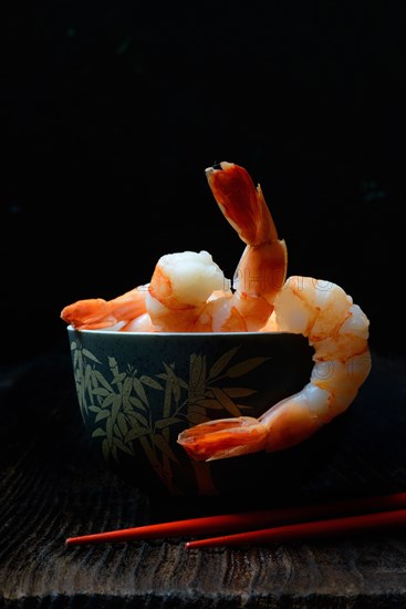 Cooked prawns in shell with chopsticks