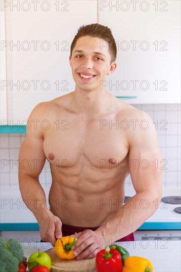 Preparing food cutting vegetables young man lunch in the kitchen healthy food vertical in germany