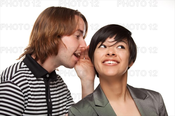 Attractive diverse couple whispering secrets isolated on a white background