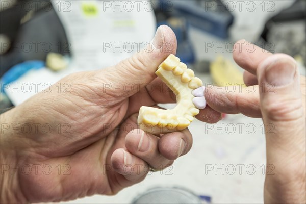 Male dental technician working on A 3D printed mold for tooth implants in the lab