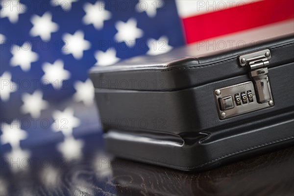 Black leather briefcase resting on table with american flag behind