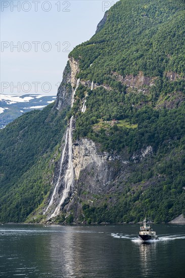 Ferry boat before a waterfall in Geirangerfjord