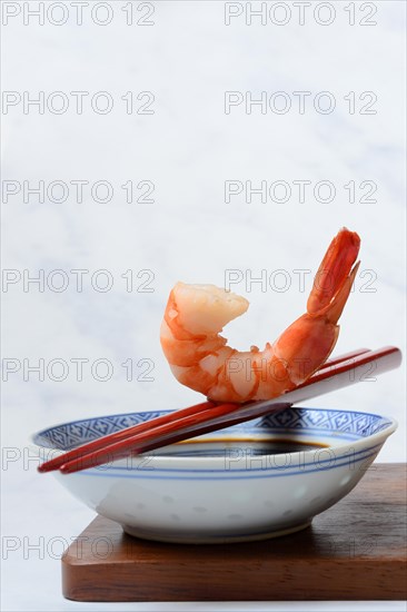 Cooked shrimp on chopsticks and shell with soy sauce