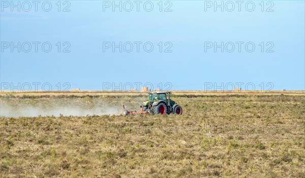 Tractor with plough on a dry field