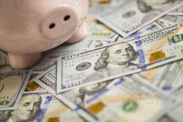 Piggy bank on stacks of newly designed one hundred dollar bills